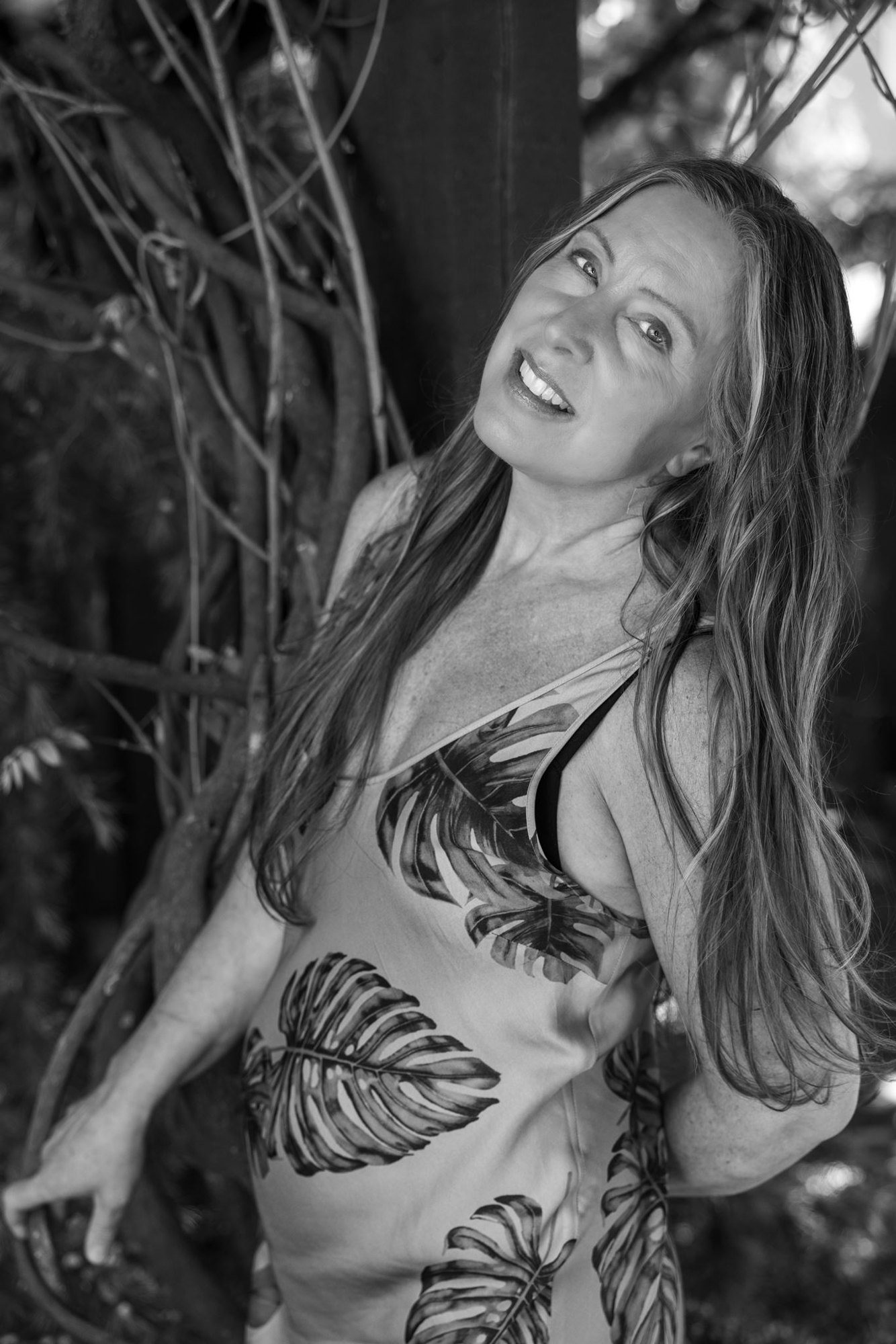Lisa Watson laughing among the garden vines, in black and white