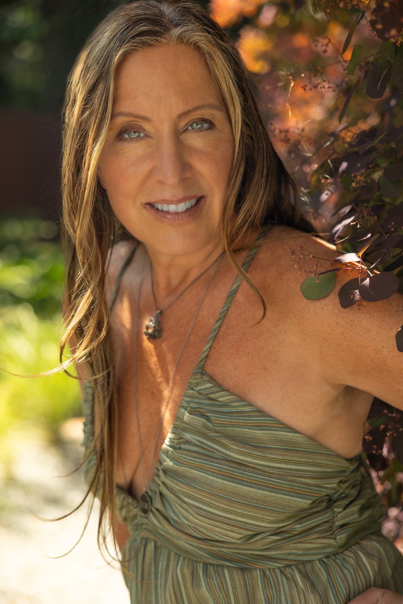 Lisa Watson smiling in her garden in a green dress