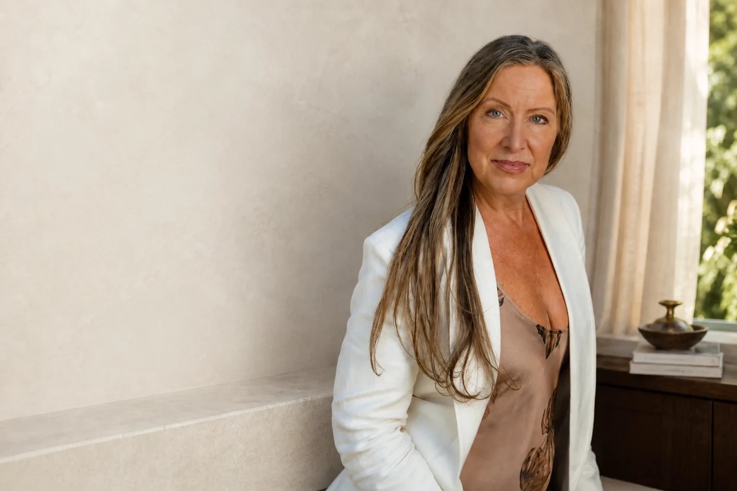 Lisa Watson standing in a white blazer in front of a white wall