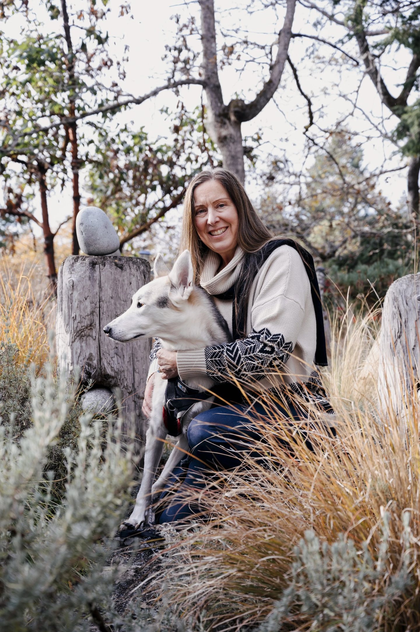 Lisa Watson sitting outdoors with a white dog